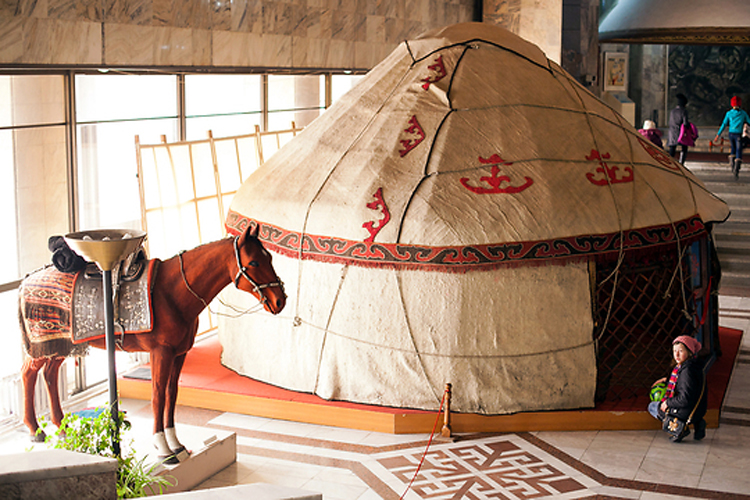 Ребенок заглядывает в модель традиционного дома кыргызских кочевников в натуральную величину, называемого юртой.