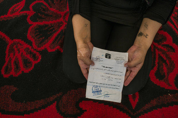 25-летняя езидка показывает «сертификат об эмансипации», который ей вручил ливиец, освободивший её. Он объяснил, что только что прошел тренировки шахидов и планировал подорвать себя, и оказался рядом с ней, чтобы освободить. Автор: Маурисио Лима / «Нью-Йорк Таймс».